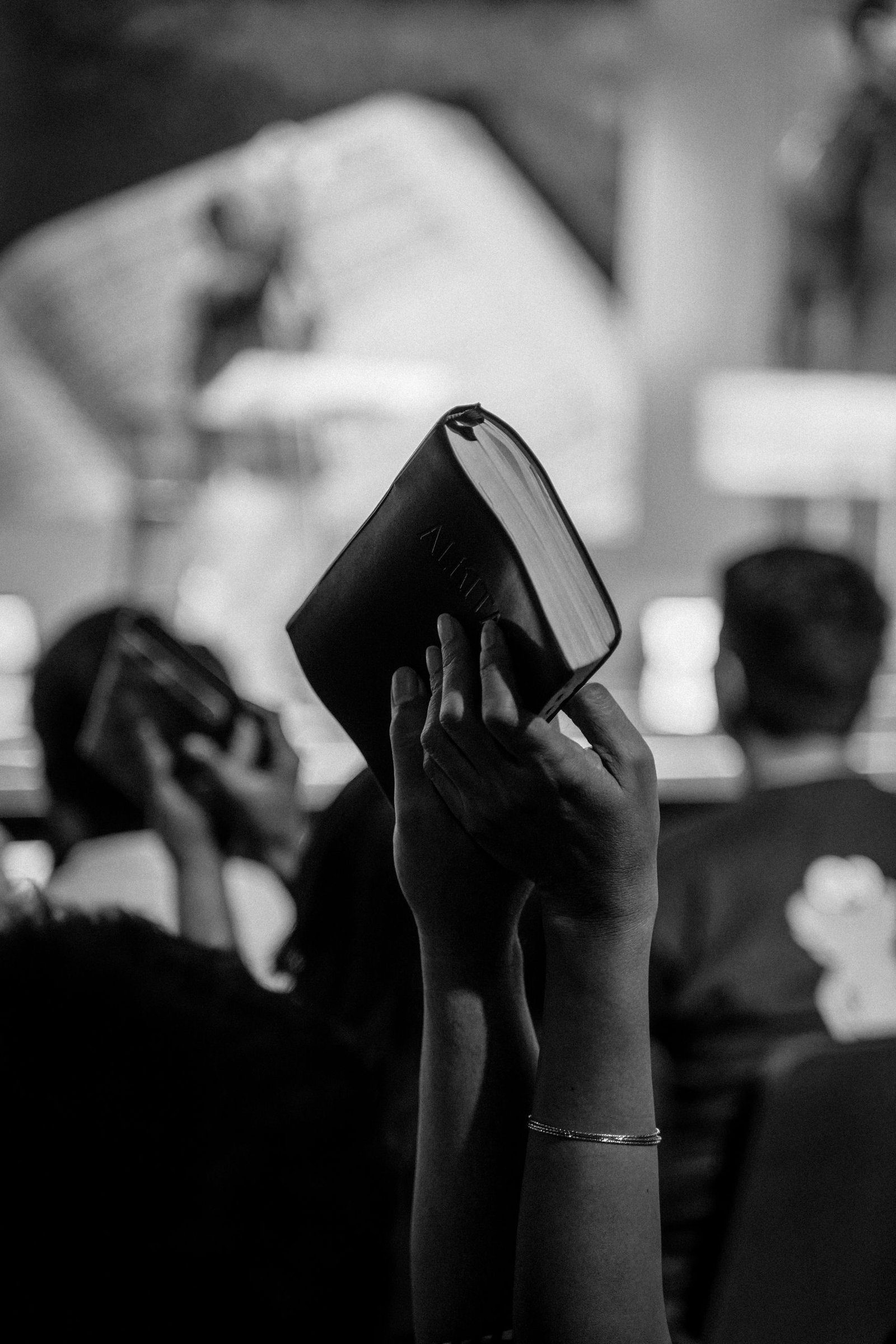 Monochrome image of a religious congregation in Jakarta, Indonesia, with raised Bibles.